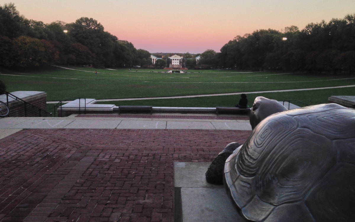 A statue of the University of Maryland mascot, a tortoise named Testudo, sits on his perch watching the sunset on the campus mall.