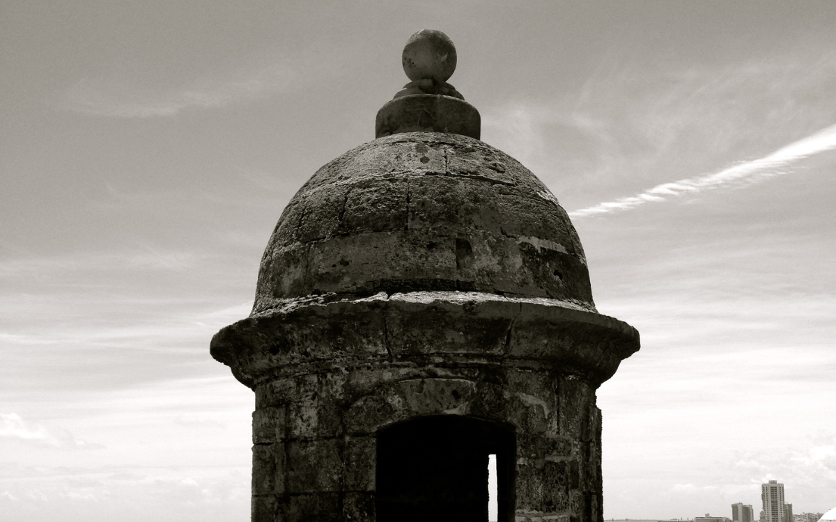 A black and white photo of a watch tower with the sky as its backdrop in San Juan, Puerto Rico.